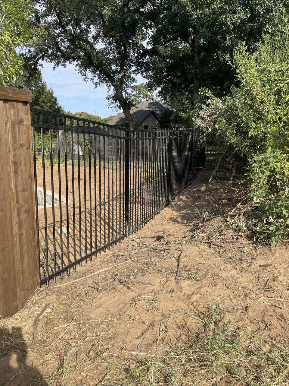 Iron fence along a wooded lot