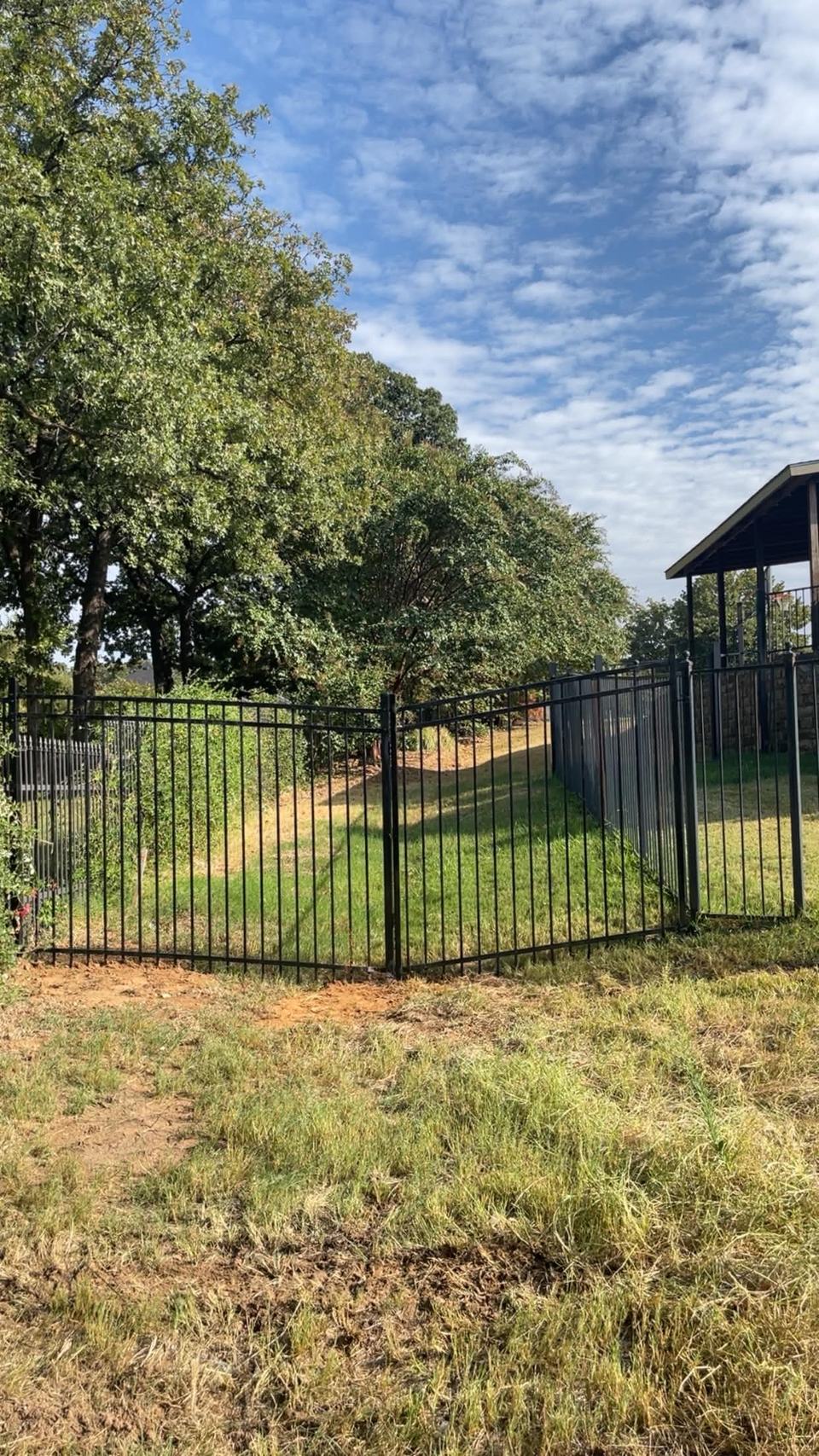Iron fence around a shaded backyard
