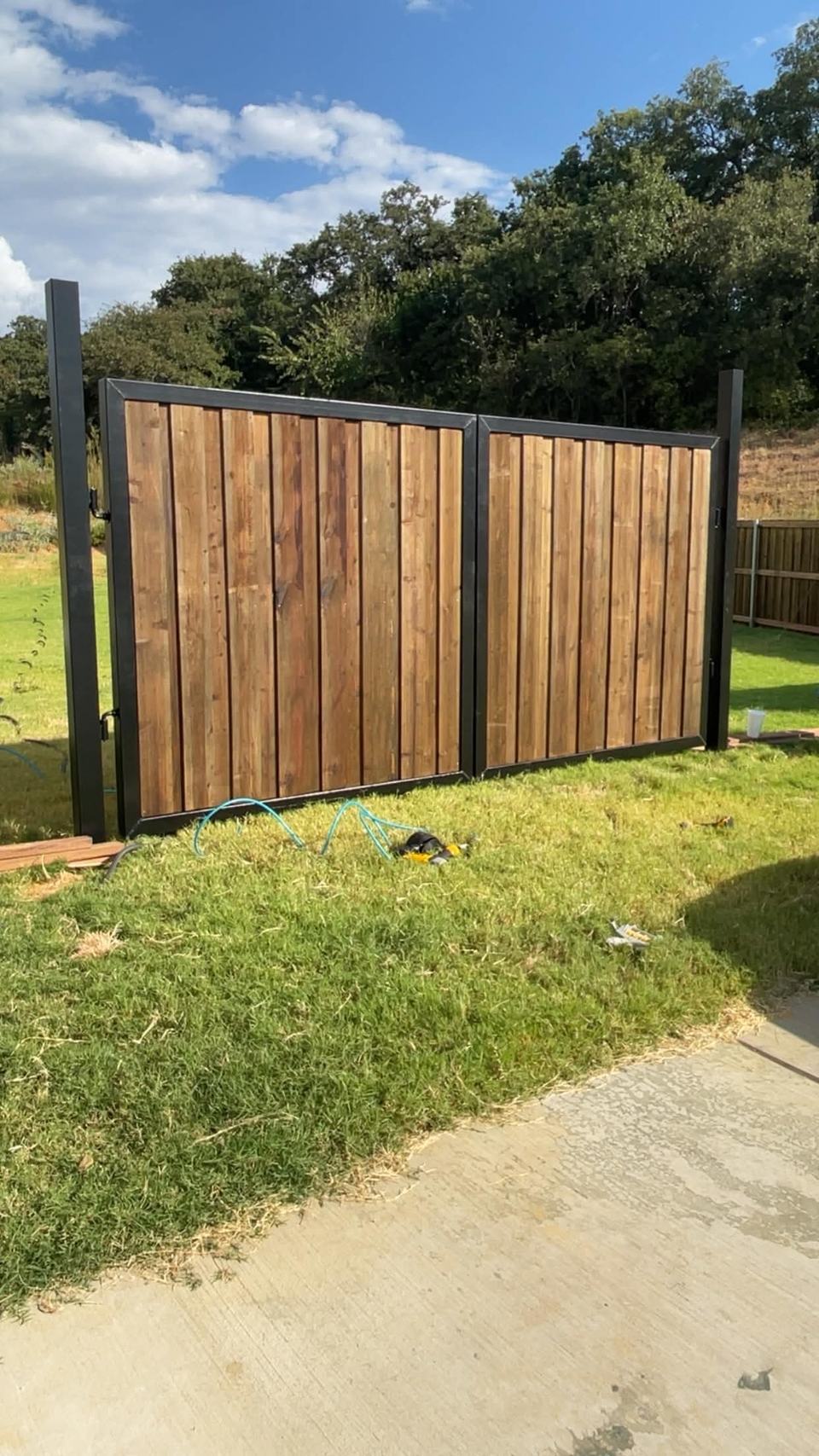 Stained cedar double drive gate on a steel frame