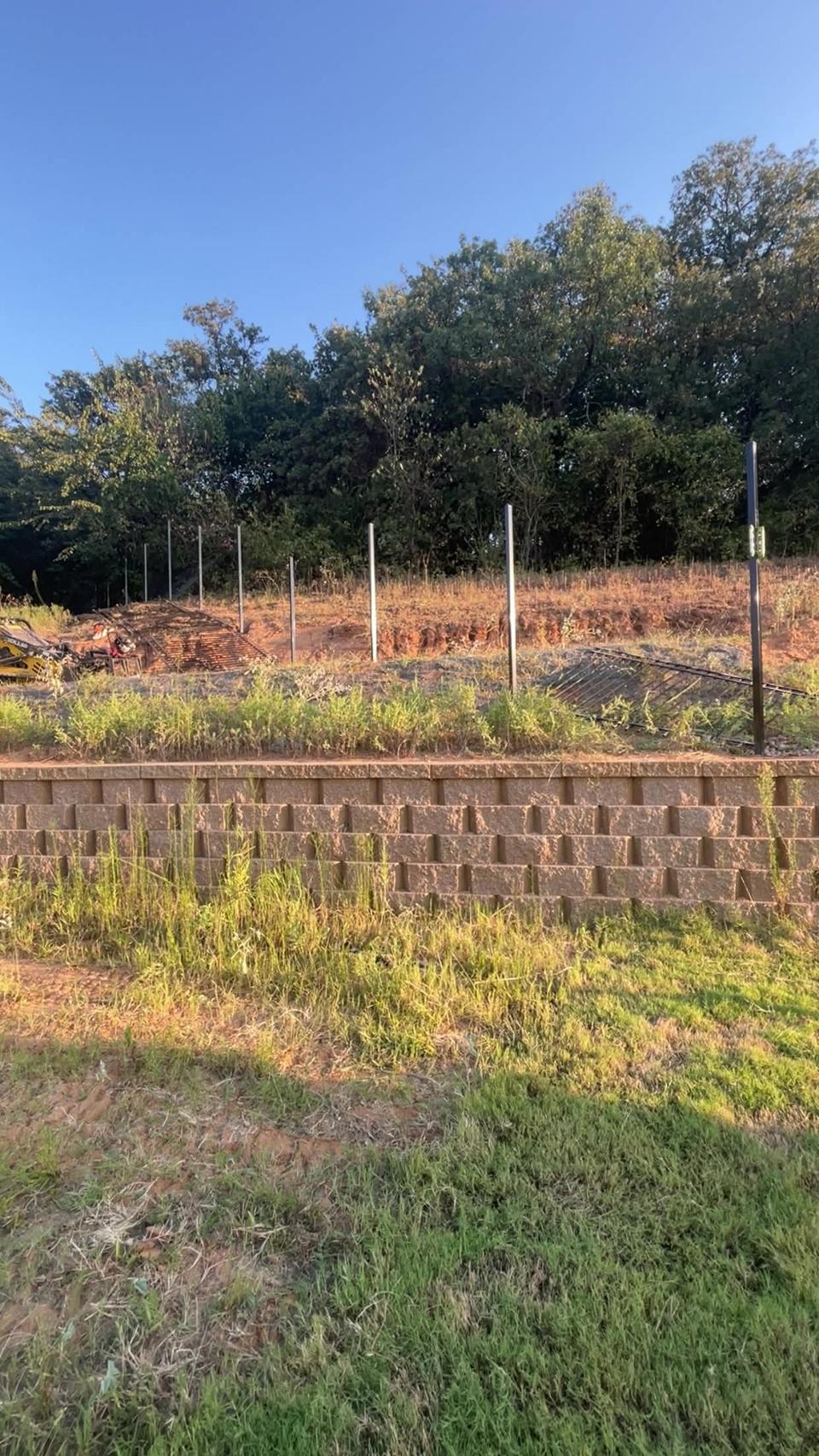 Steel posts set above a block retaining wall